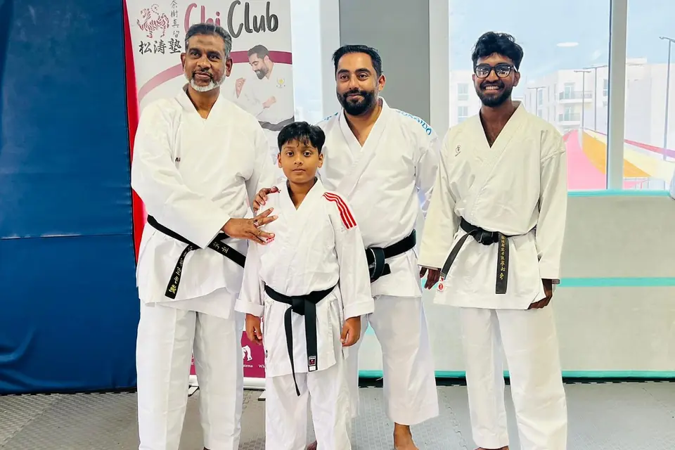 Instructors presenting a young student with his new belt