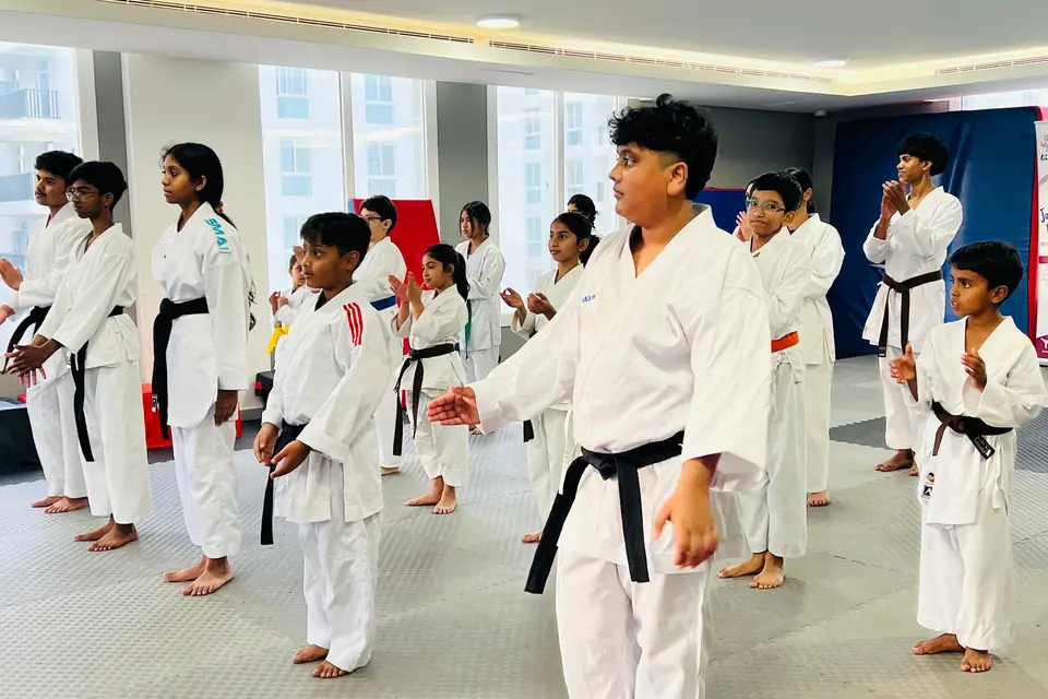 A black-belt instructor leading a children's class
