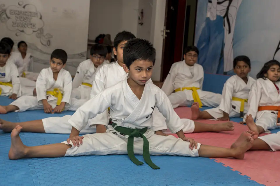 Young students stretching on the dojo mats