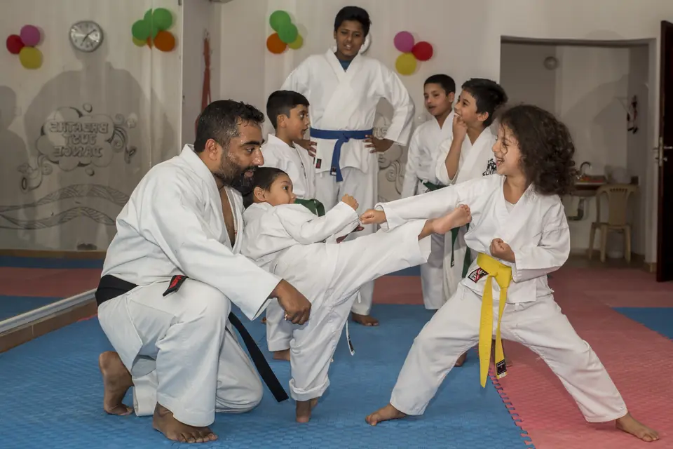 Two young students practising kicks with Sensei Najmal