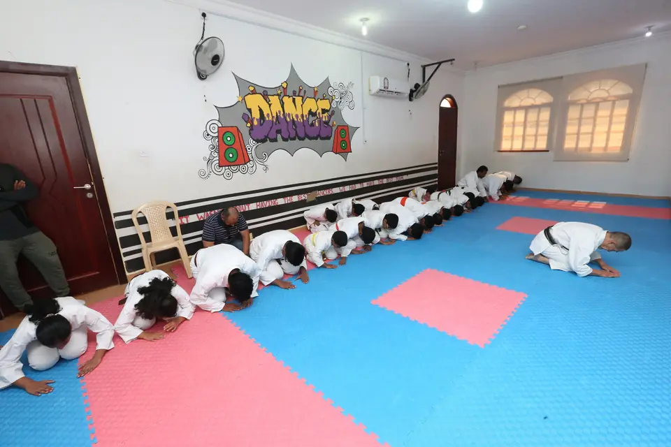 Students kneeling in line to bow at the start of class
